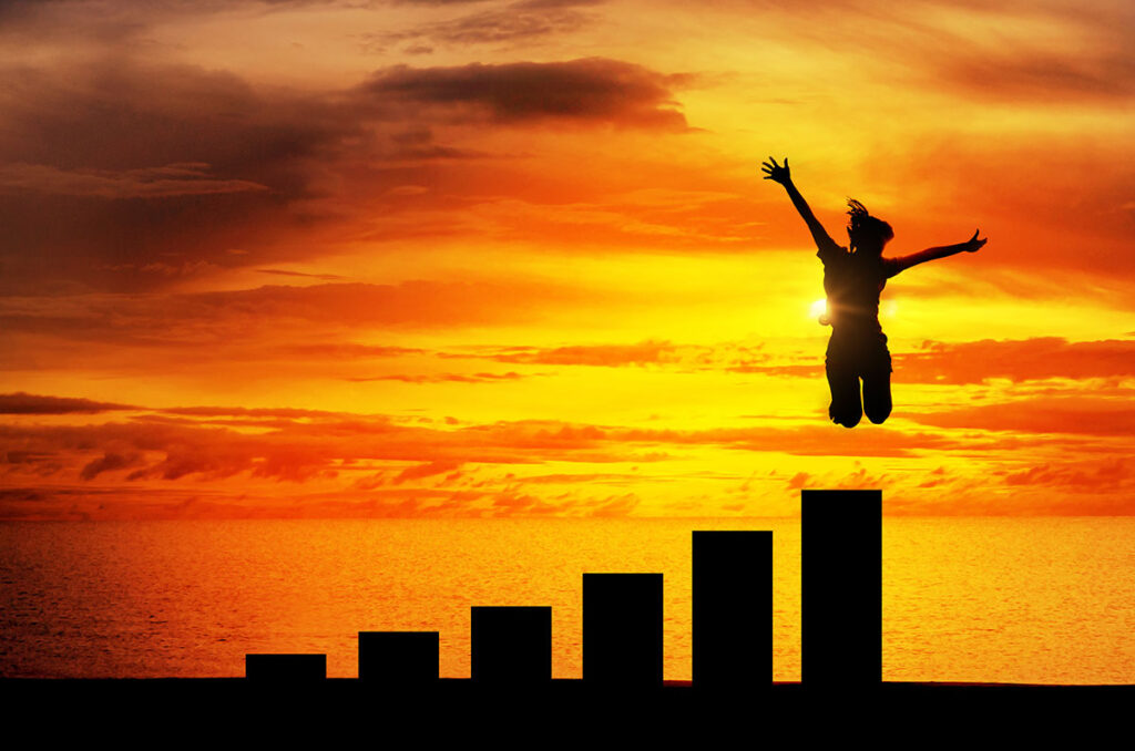 silhouette of a woman facing sunset jumping over tall bars representing growth